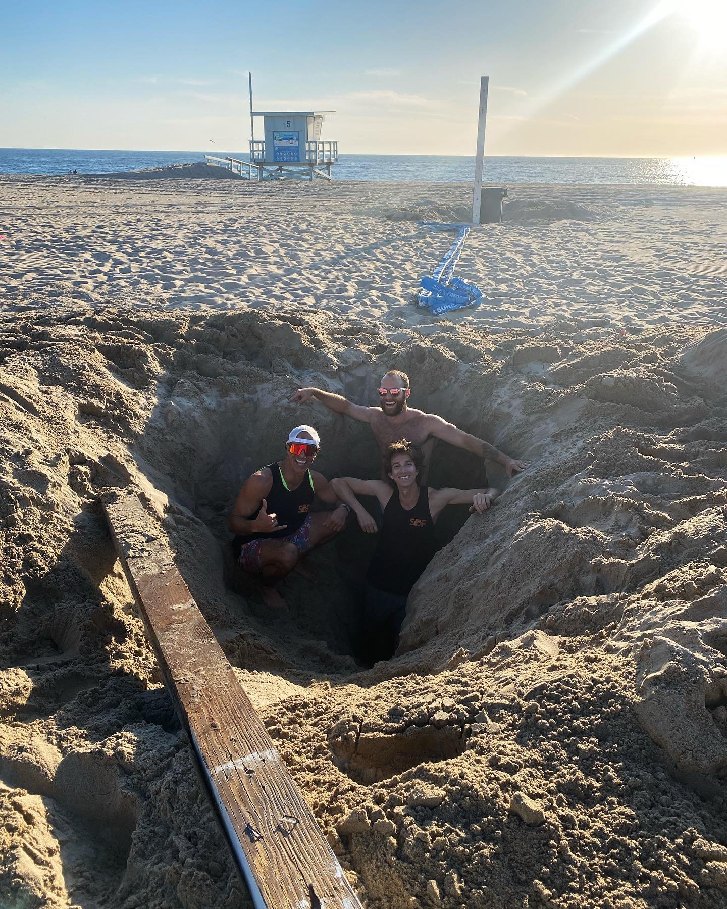 SBF volunteers standing in a deep hole dug to reset a court pole on 5th Street